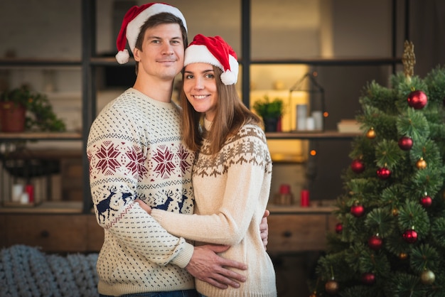 Mid shot couple wearing sweaters embracing eachother