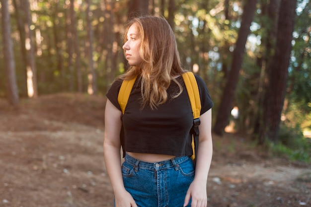 Free Photo mid shot girl with backpack in forest