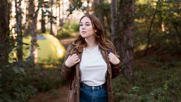 Free Photo mid shot girl with backpack in front of tent