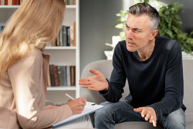 Free photo mid shot man talking to woman therapist