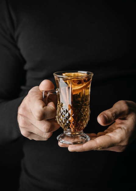 Free photo mid shot person holding glass with winter drink