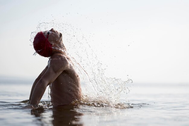 Mid shot swimmer splashing out of water