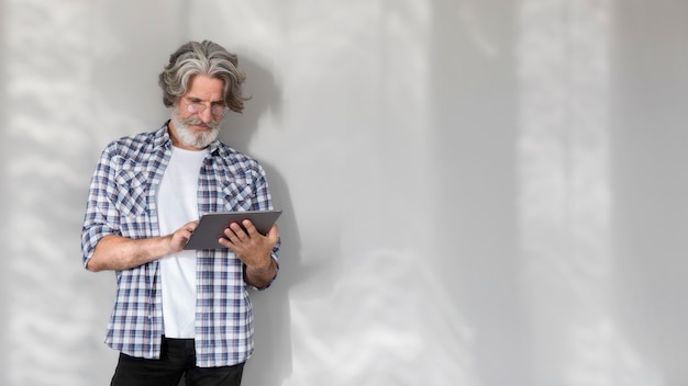 Mid shot teacher standing and holding tablet with copy-space