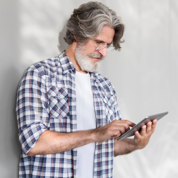 Mid shot teacher standing and holding tablet