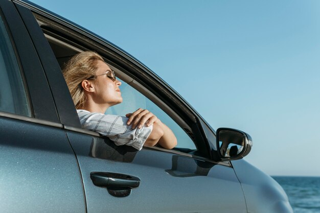 Mid shot woman in car looking at sea