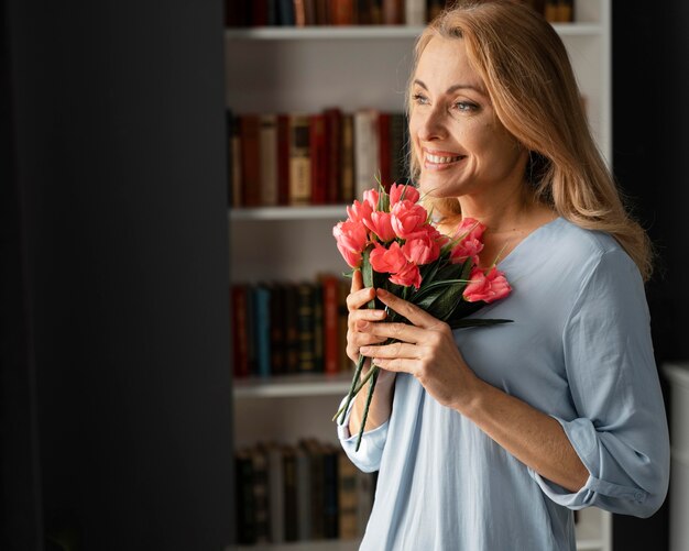 Mid shot woman counselor holding flowers bouquet