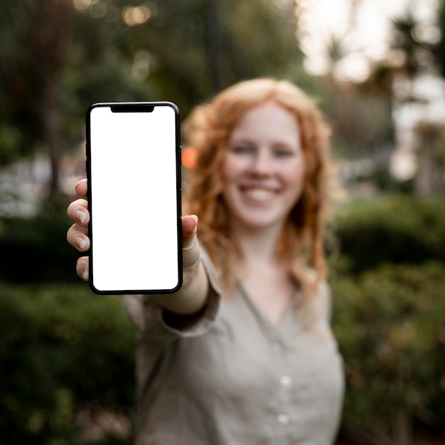 Free Photo mid shot woman holding blank phone