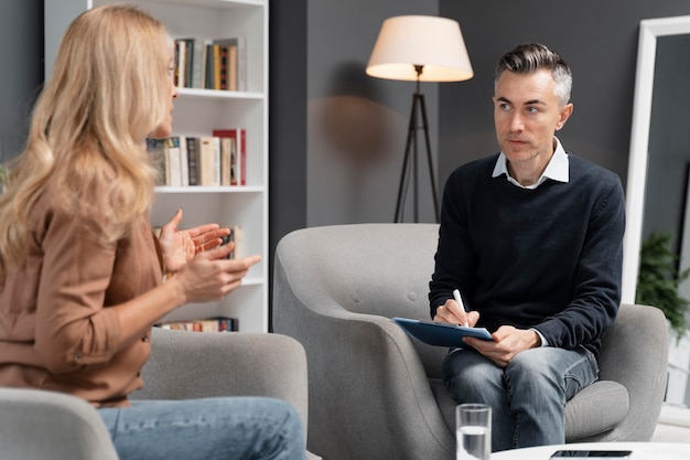 Free photo mid shot woman talking to man therapist