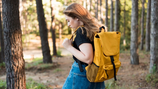 Free Photo mid shot woman with backpack in forest