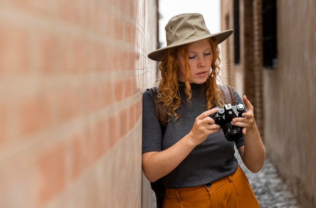 Free photo mid shot woman with hat looking at camera