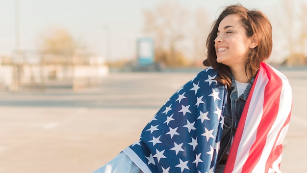 Mid shot young woman wearing big usa flag