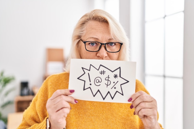 Free photo middle age blonde woman business worker holding shooting message banner at office