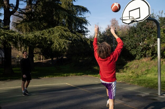 Middle age friends having fun together playing basketball