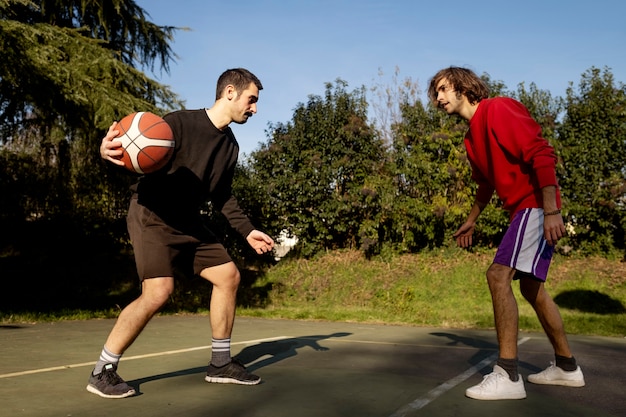 Middle age friends having fun together playing basketball