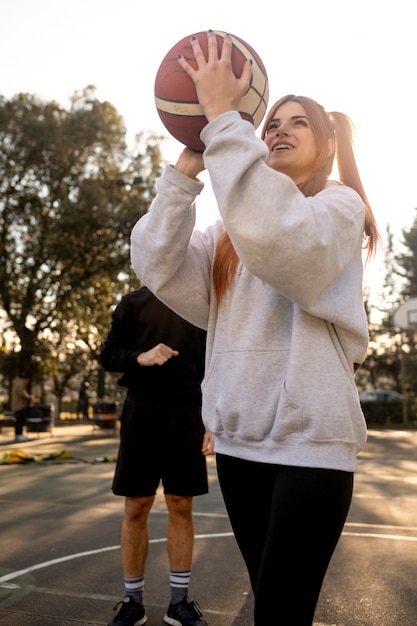 Middle age friends having fun together playing basketball