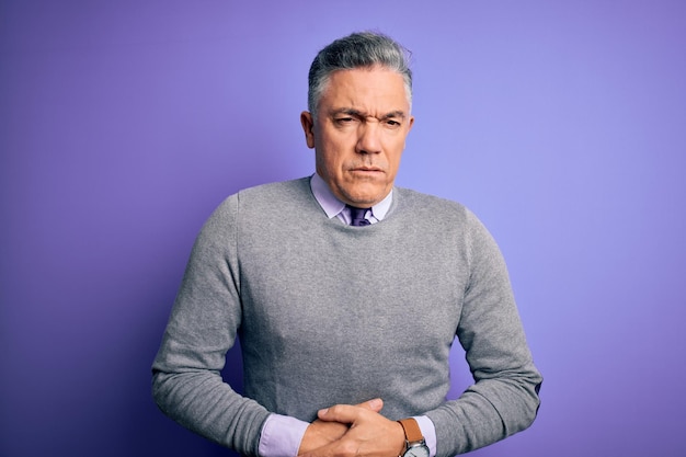 Free Photo middle age handsome greyhaired man wearing elegant sweater over purple background with hand on stomach because indigestion painful illness feeling unwell ache concept