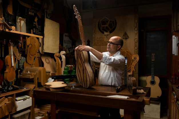 Middle aged man making instruments in his workshop alone