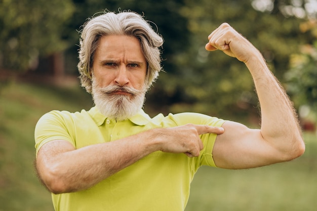 Middle aged sportsman pointing on his biceps