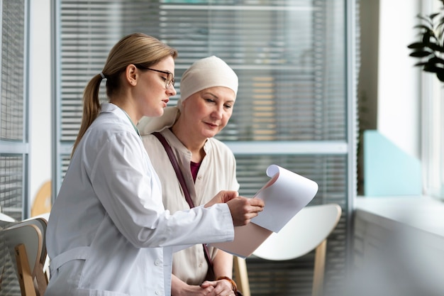 Free photo middle aged woman with skin cancer talking with her doctor