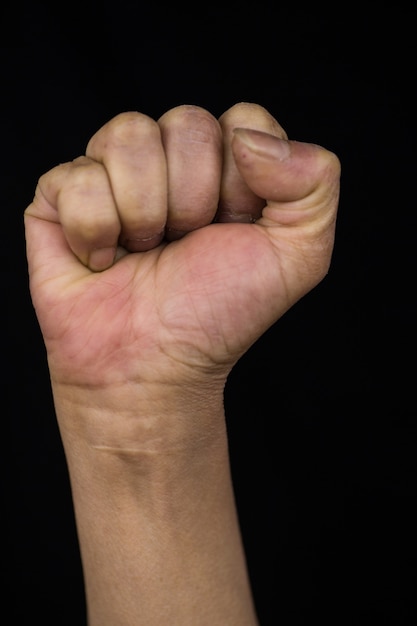 Free photo middle-aged woman with stretched up arm showing her fist showing women empowerment and rights