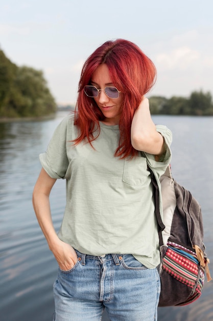 Middle shot girl posing in front of lake