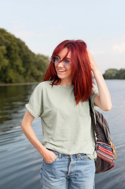 Free Photo middle shot woman posing in front of lake