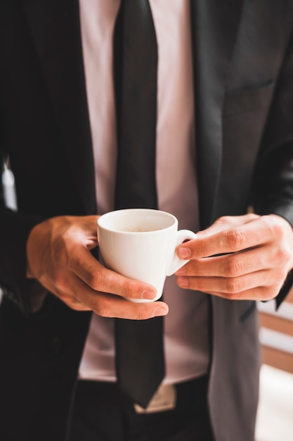 Free photo midsection of businessman holding coffee cup