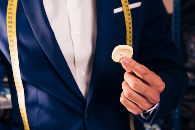 Free photo midsection of a male tailor showing white button