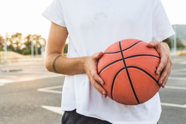 Free Photo midsection view of a man holding basketball