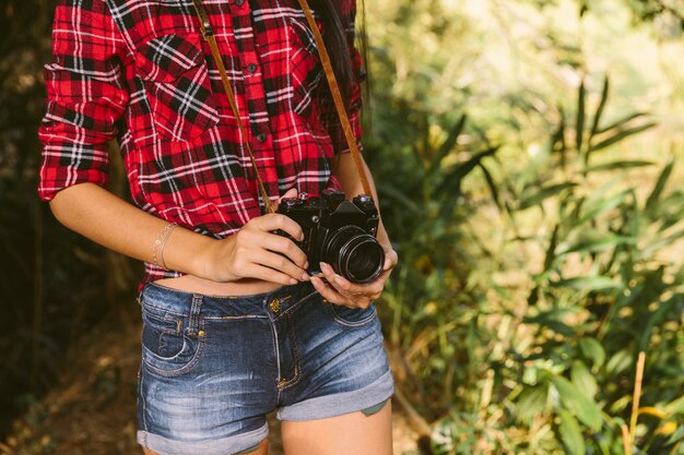 Midsection view of a woman holding camera