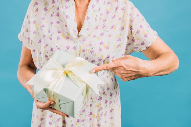 Midsection view of a woman pointing at birthday gift