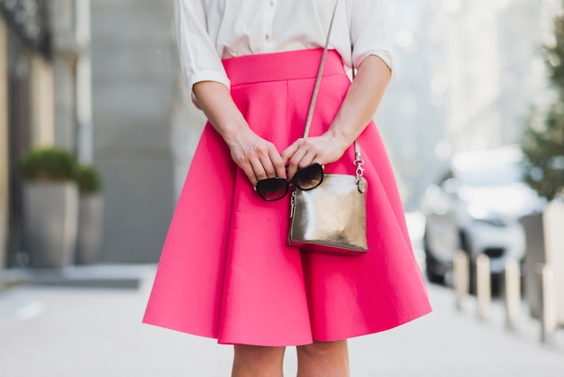 Free Photo midsection view of a woman with sunglasses and handbag