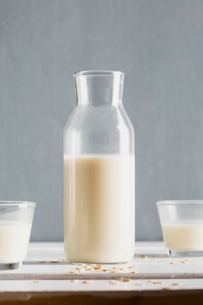 Milk bottle with glasses on table