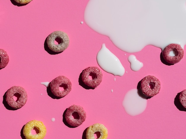 Milk and cereals on pink background close-up