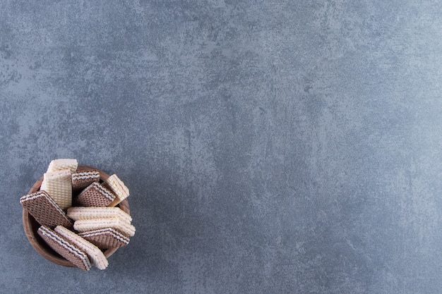 Milk and chocolate wafers in a bowl , on the marble background.