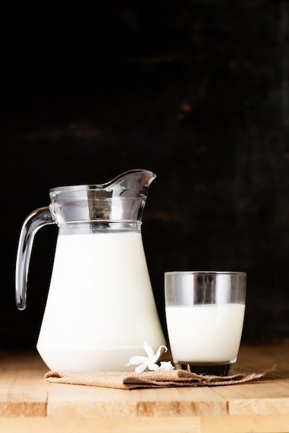 Free Photo milk in glass and jug on wooden table