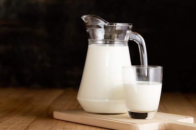 Free Photo milk in glass and jug on wooden table