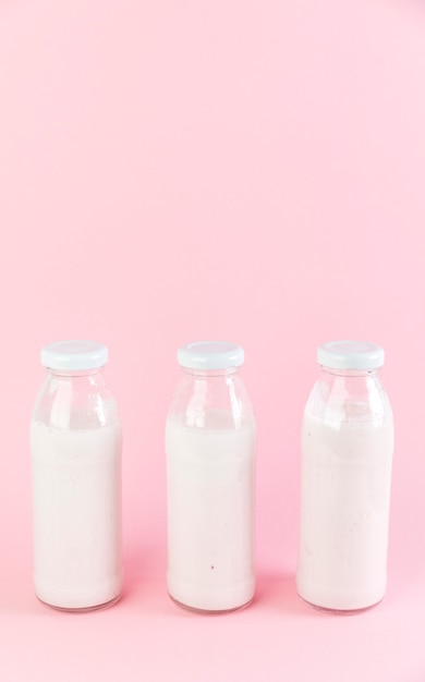 Free photo milkshake bottles on pink background