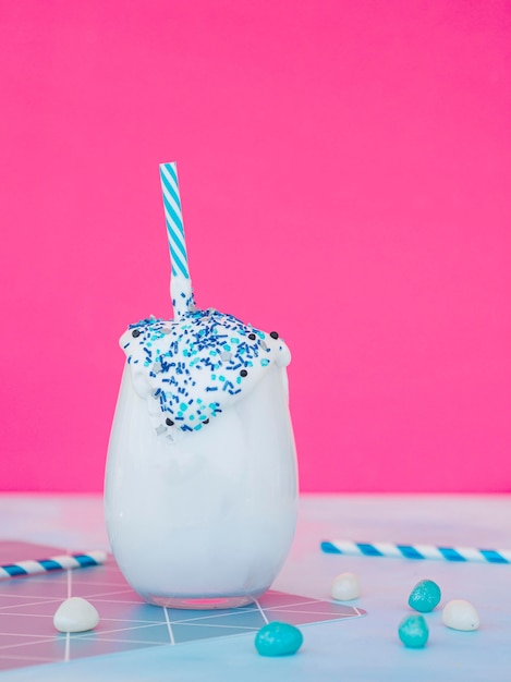 Free Photo milkshake glass with pink background