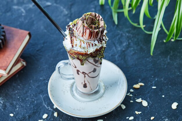 Free photo milkshake with cone, chocolate , sprinkles and in the dark surface