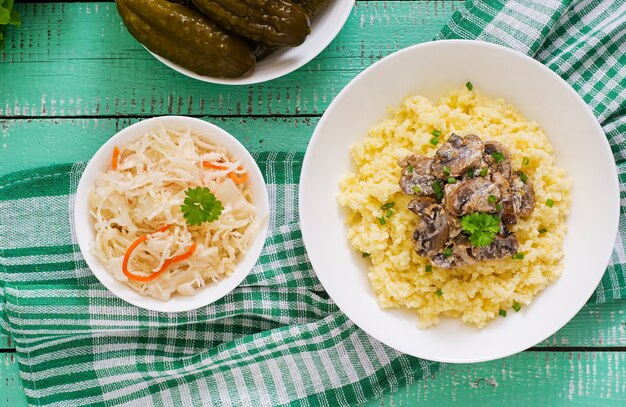 Millet porridge with mushrooms in a white bowl.