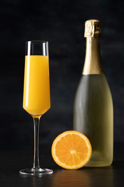 Mimosa cocktail with bottle and orange slice