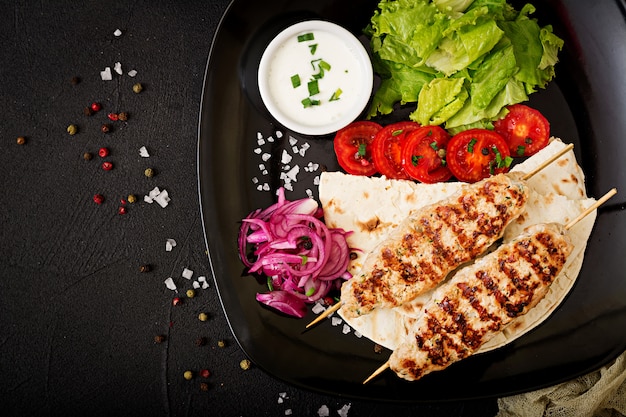 Free photo minced lula kebab grilled turkey (chicken) with fresh vegetables. top view