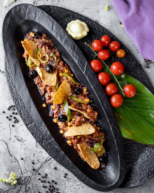 Minced meat with corn olive and pepper served with tortilla chips