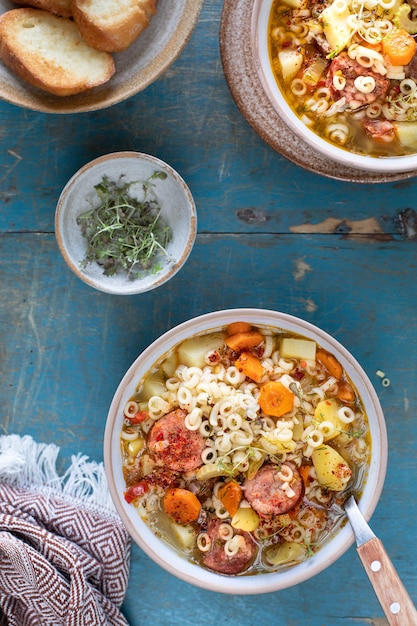 Free photo minestrone soup in a pan on a light table top view italian soup with pasta and seasonal vegetables delicious vegetarian food concept