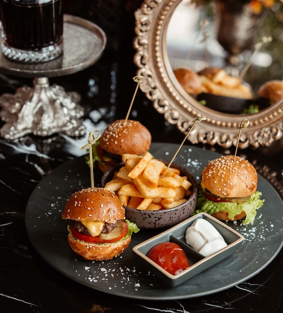 Mini cheeseburgers and fries on a plate