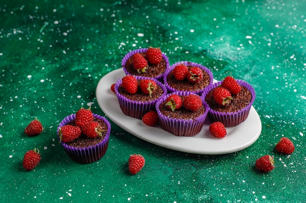 Mini chocolate sufle cupcakes with raspberries.