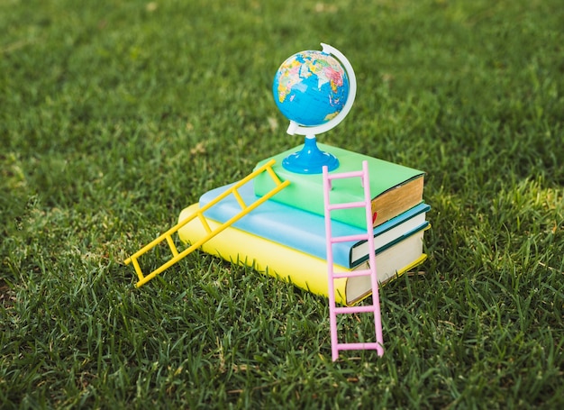 Free photo mini globe on top of textbook pile