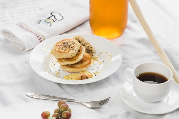 Free photo mini pancakes with banana; honey and chia seeds on plate