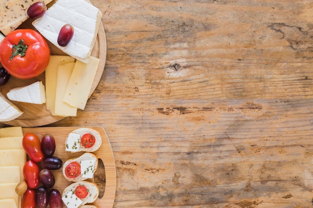 Free photo mini sandwiches with cheese blocks and tomatoes on wooden desk